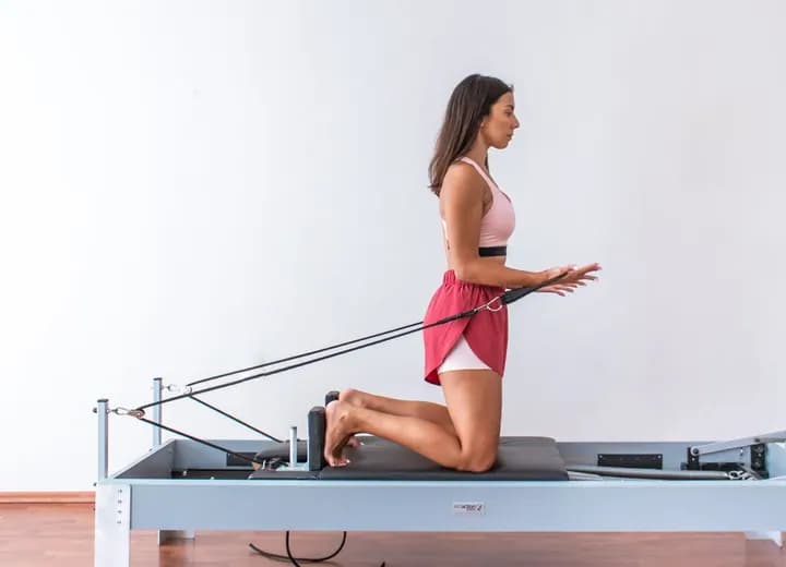 Aluna praticando exercício em aparelho de pilates